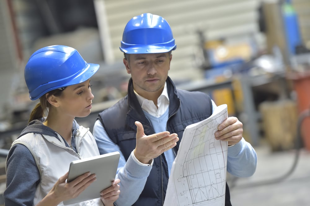 Engineers in mechanical factory reading instructions